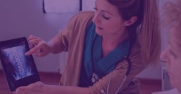 nurse pointing at x-ray on computer tablet